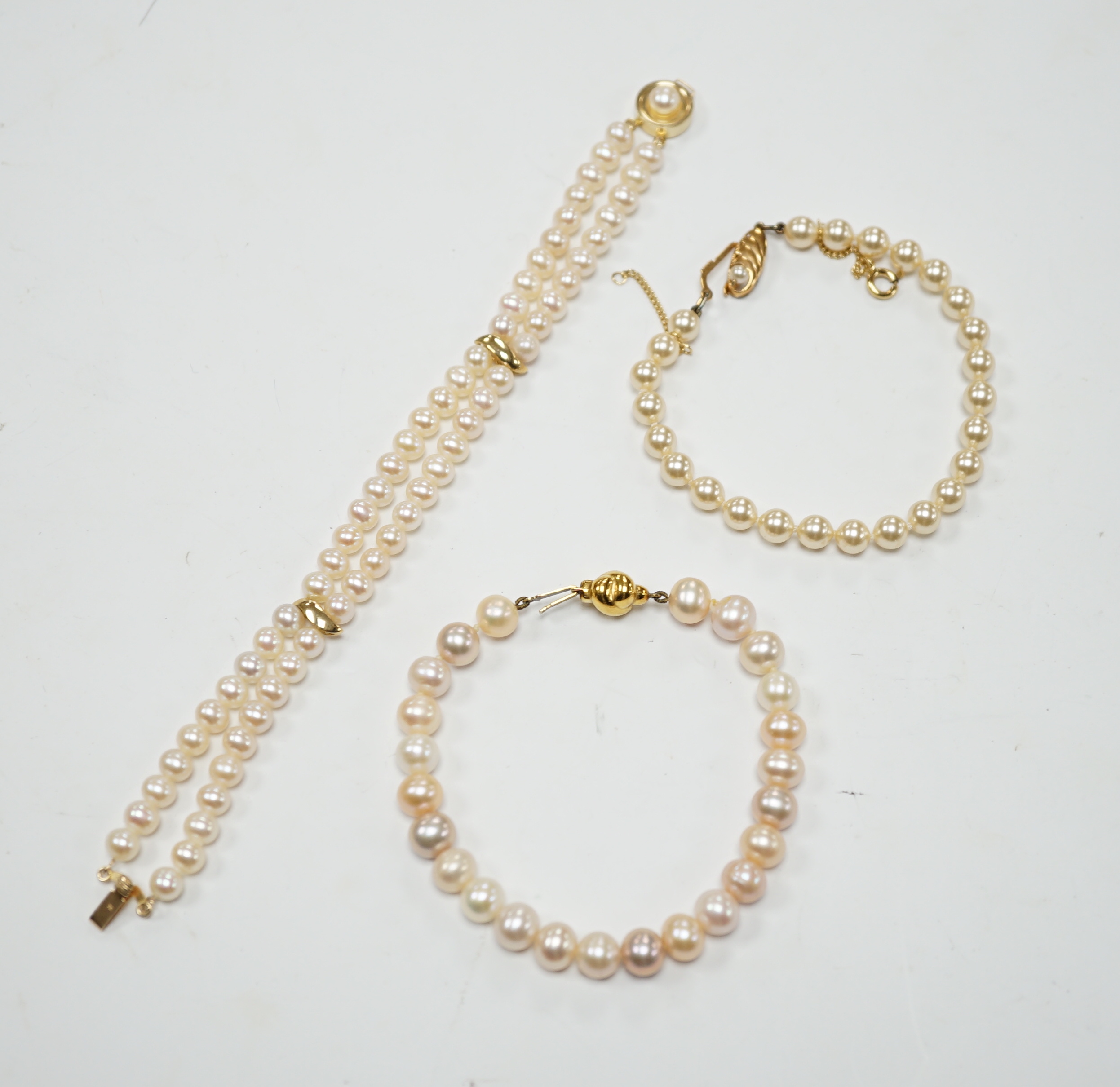 A modern double strand cultured pearl bracelet, with 14k clasp, 18cm, one other cultured pearl bracelet with 375 clasp and a simulated pearl bracelet.